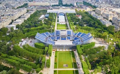 an aerial view of a stadium with raised seating surrounded by green parkland